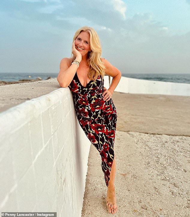 Пенни Ланкастер, 52 года, выглядит сияющей в платье с глубоким цветочным принтом, когда она позирует на пляже в Марбелье.
