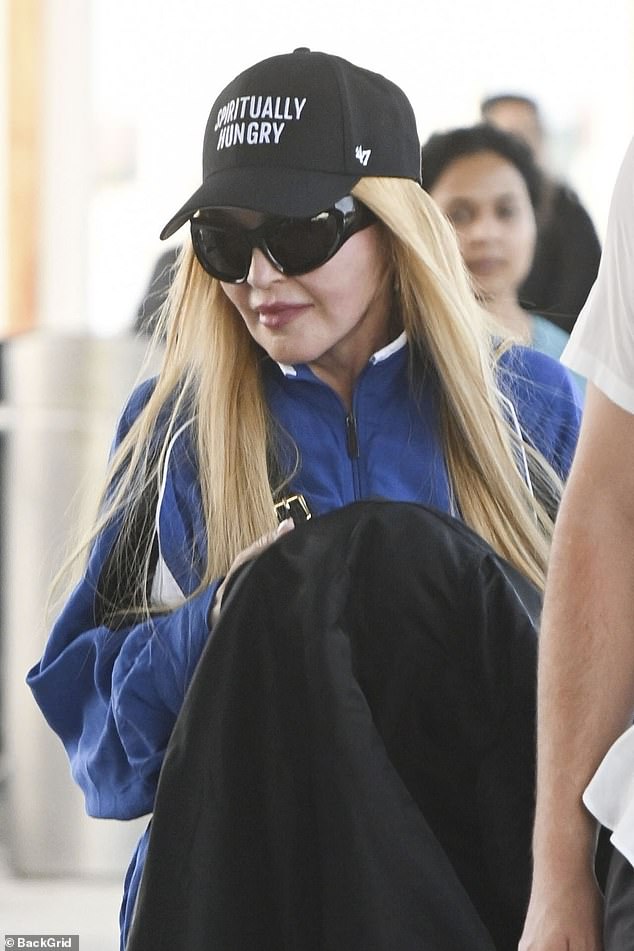 Вверху: Мадонна слегка улыбнулась при посадке в аэропорту