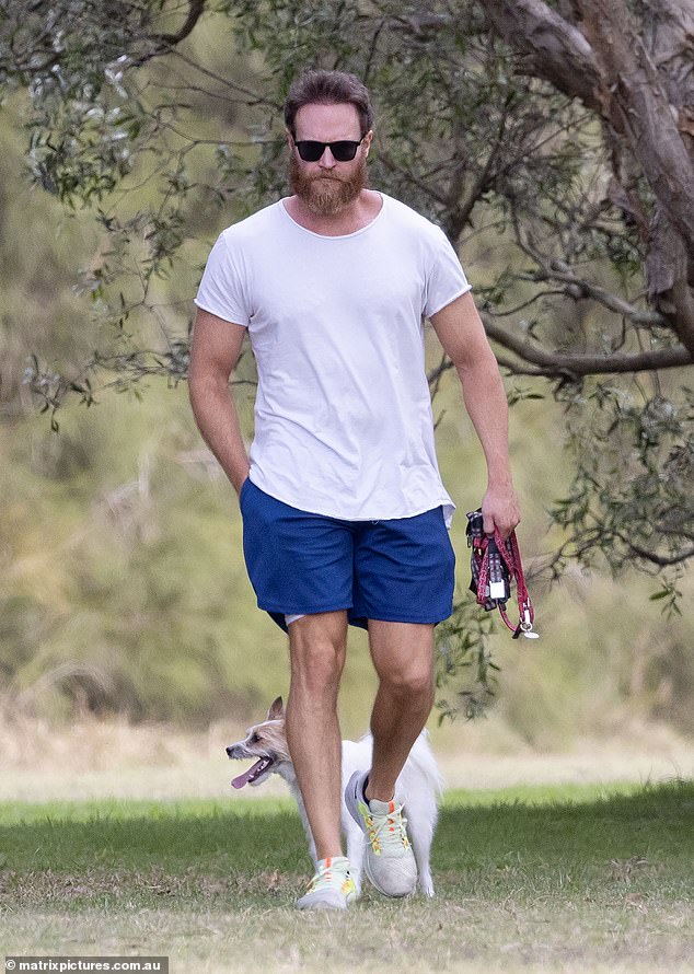 Австралийский актер Джош Лоусон выглядит неузнаваемым с густой бородой и выглядит одиноким, выгуливая свою собаку на Золотом Берегу на фоне скандала с изменой «папиного дома».