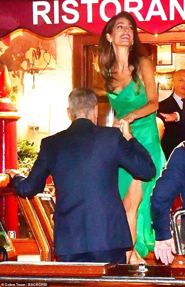 Джордж Клуни выглядит стильно в темном костюме, а его жена Амаль гламурна в изумрудном платье на ужине в Венеции.