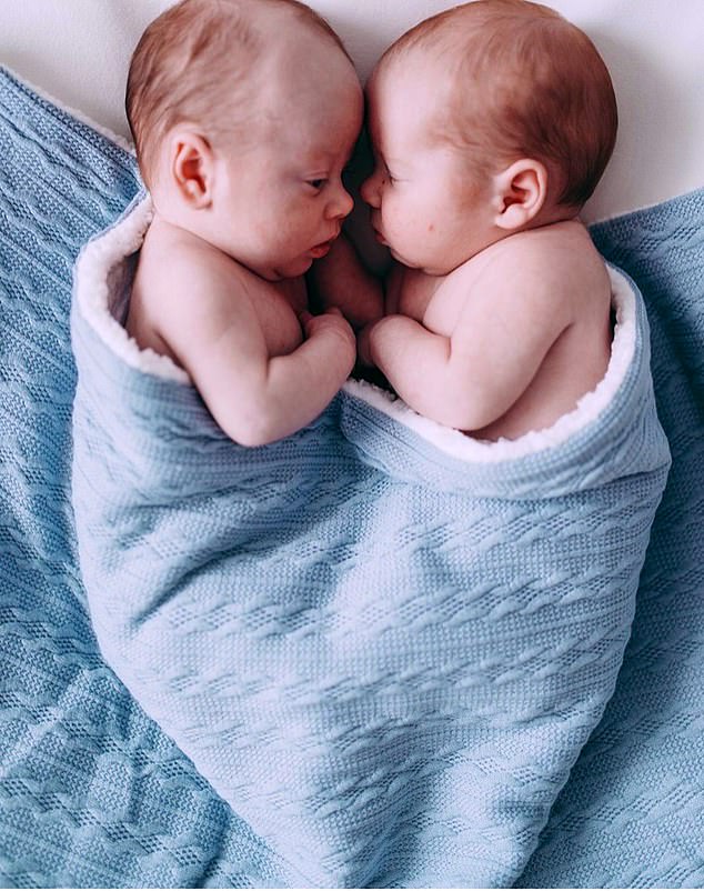 Очаровательно: два мальчика по имени Феникс Бобби и Хантер Джордж лежат вместе под синим одеялом.