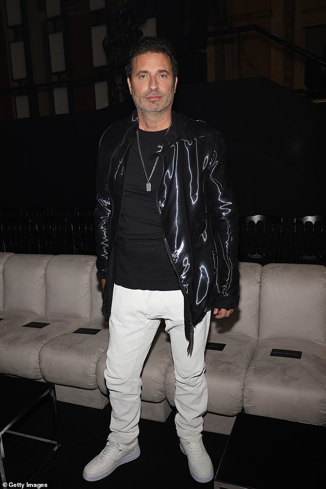 Выделяется: Ричард Орлински привлек внимание в черной блестящей флуоресцентной куртке в сочетании с черной футболкой и белыми джинсами.