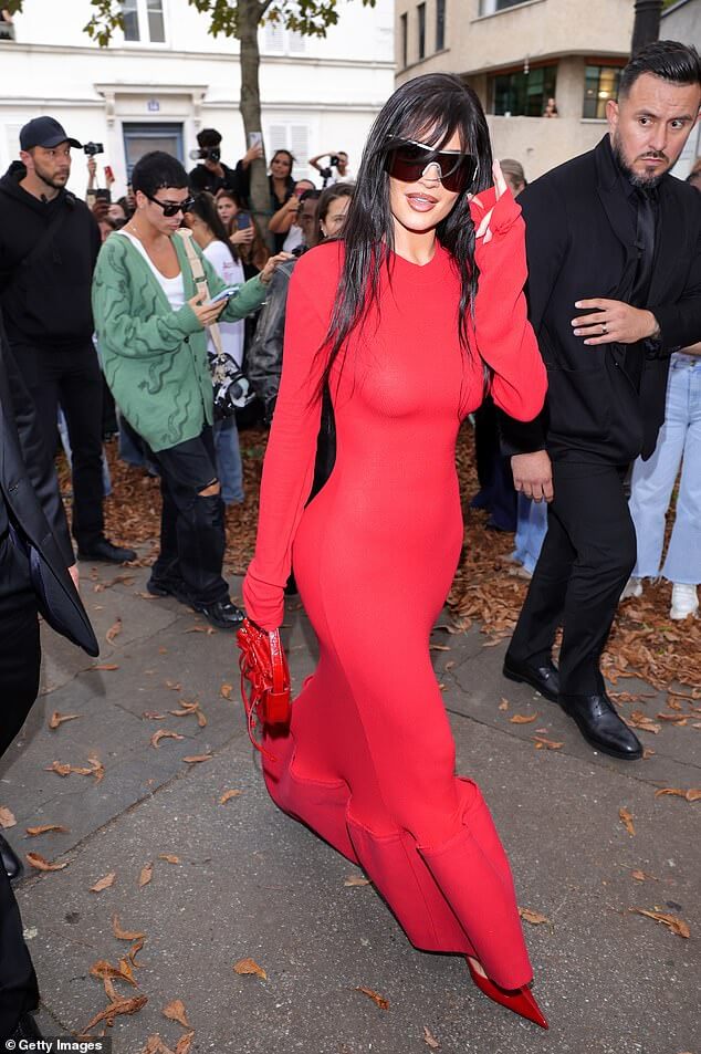 Кайли Дженнер демонстрирует свою сенсационную фигуру в обтягивающем красном платье, дебютируя с новой челкой в ​​стиле ретро на показе Acne Studios во время Недели моды в Париже.