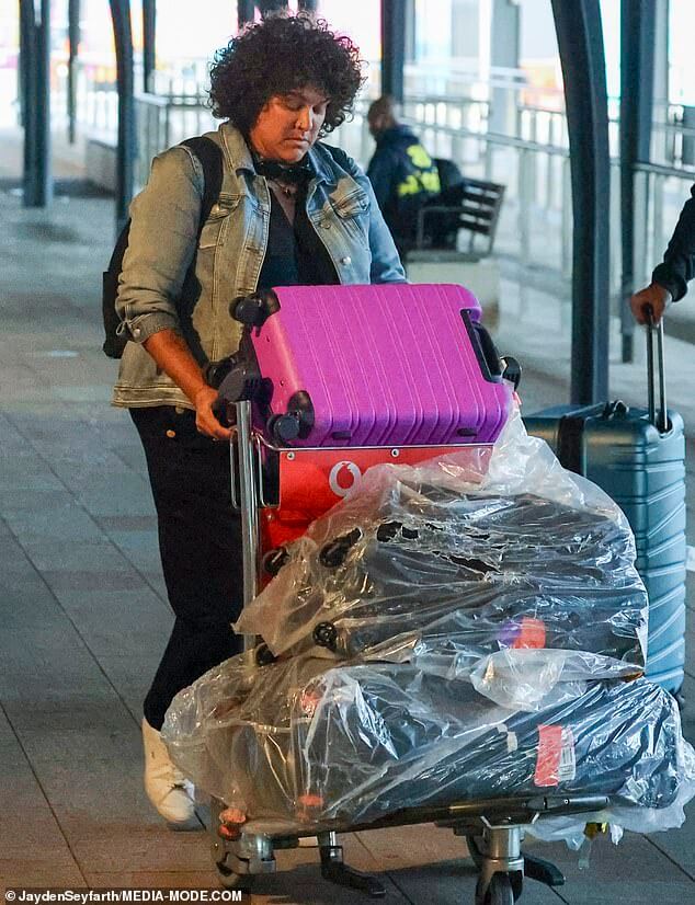На суше!  Кейси Донован прилетает в Сидней с тележкой, полной багажа, и наконец возвращается домой после того, как несколько дней провела в ловушке в суровую погоду на смертельно опасном фестивале Burning Man.