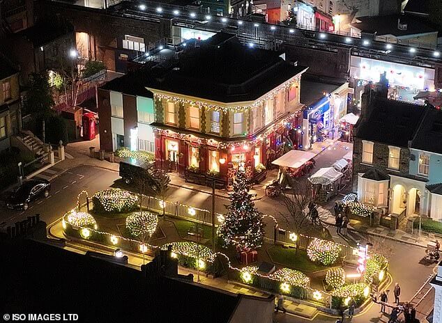 Захватывающе: декорации EastEnders были освещены рождественскими огнями в среду вечером, когда начались съемки драматических эпизодов детективного убийства.