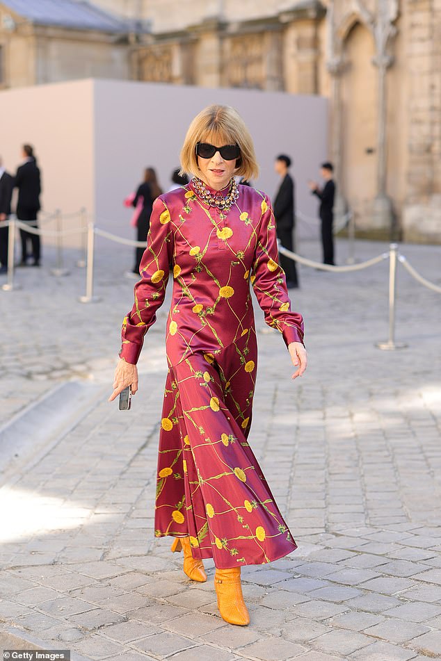Хорошо выглядит: Анна Винтур выглядела гламурно в красно-желтом атласном платье-макси во время Недели моды в Париже.