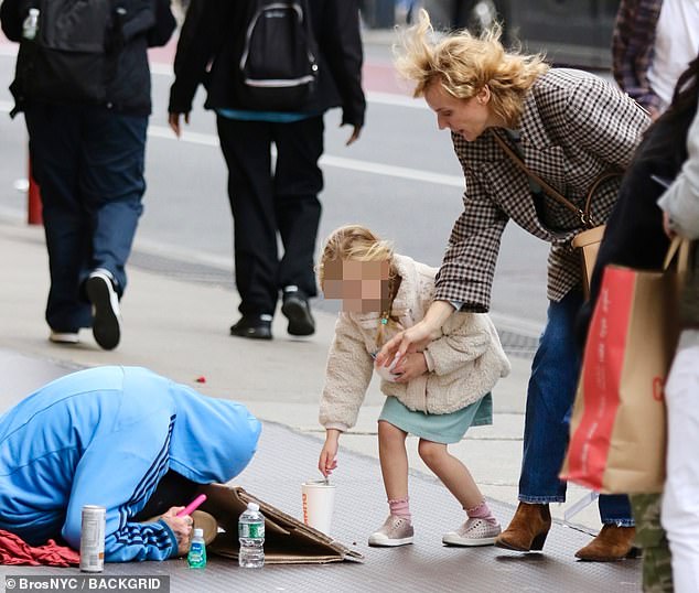 Диана Крюгер улыбается своей четырехлетней дочери Нове после того, как она дала деньги бездомному, находясь на Манхэттене