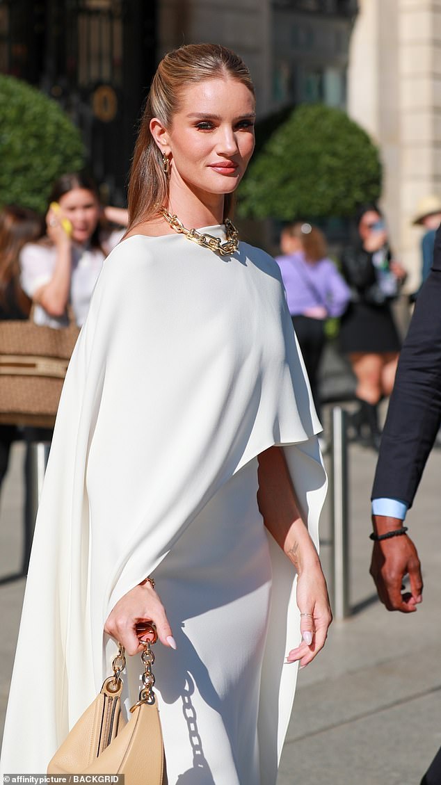 Рози Хантингтон-Уайтли выглядит воплощением шика в кремовой накидке вместе с Пэрис Хилтон, Флоренс Пью и Эндрю Гарфилдом на показе Valentino во время Недели моды в Париже.