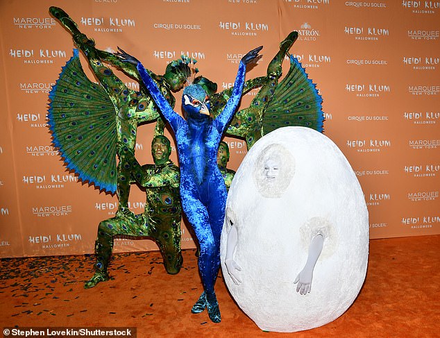 Павлинье яйцо?  Она стояла рядом со своим 34-летним мужем Томом Каулитцем, который был одет как большое белое яйцо.