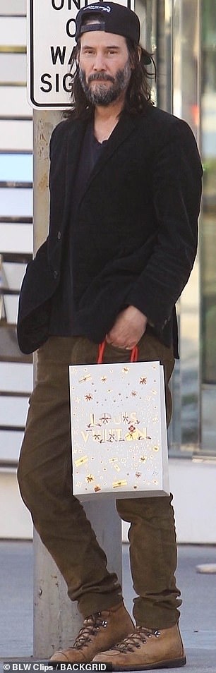 Взявшись за дело: размахивая сумкой с рождественской тематикой из роскошного торгового центра, звезда «Матрицы» выглядел непринужденно, стуча по тротуару в коде города 90210.