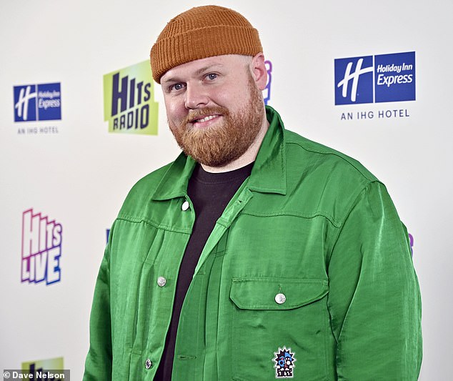 Уютно: 31-летний Том Уокер в другом месте выглядит повседневным образом в зеленой джинсовой куртке, черной футболке и оранжевой шапке.