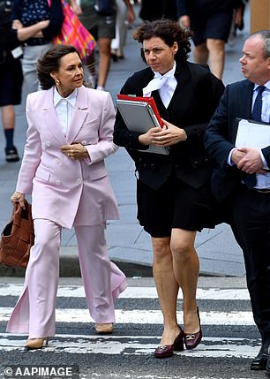 Уилкинсон в первый день суда (слева) в бледно-розовом костюме и ее адвокат в бордовых туфлях Ferragamo.