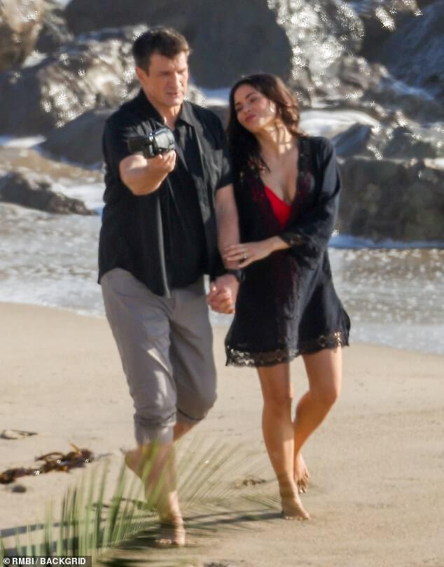 Дженна Деван блистает в черном халате поверх красного купальника, обнимаясь с Натаном Филлионом на пляже в Малибу… но это все для шестого сезона «Новичка».