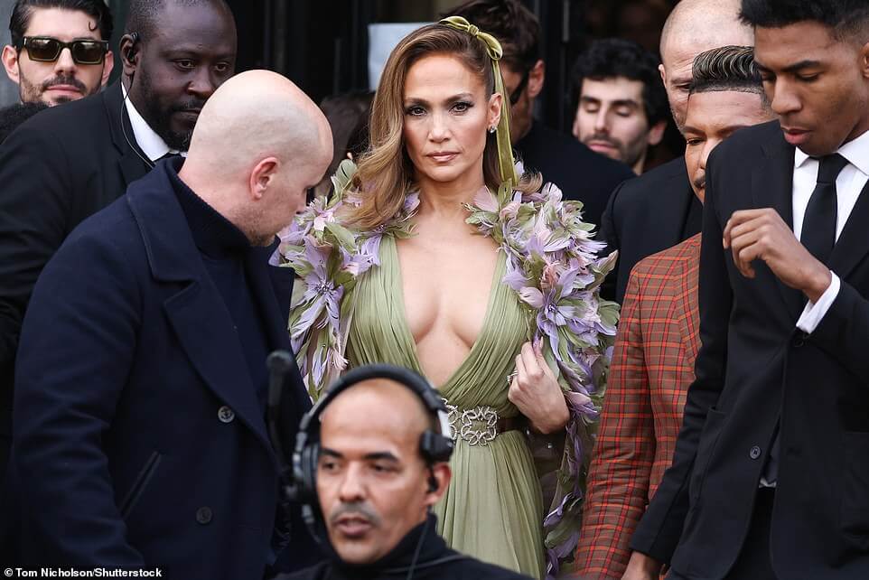 У нее все еще есть это!  54-летняя Дженнифер Лопес привлекает внимание прохожего в глубоком платье цвета шалфея и невероятной накидке с цветочным принтом, возглавляя появление звезд на показе Elie Saab во время Недели моды в Париже.