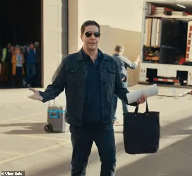В центре ролика Дженнифер стоит на съемочной площадке со своей сумкой из Uber Eats, когда Дэвид приходит на съемочную площадку.