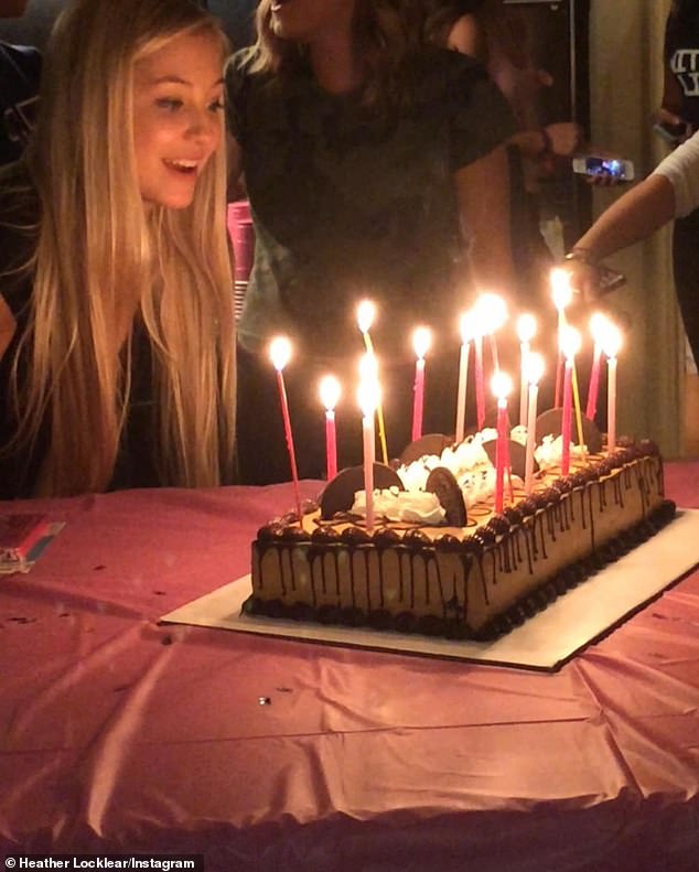 Было изображение, где Ава задувала розовые и красные свечи на своем шоколадном праздничном торте.
