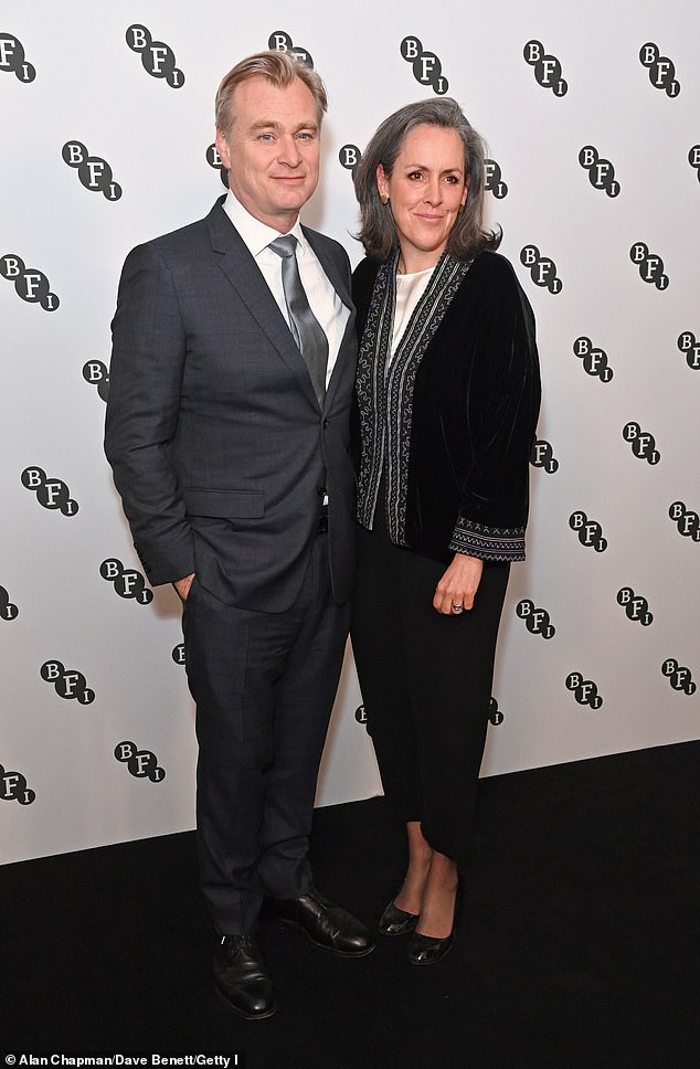 Кристофер был одет в темно-серый костюм и позировал перед камерами вместе со своей женой Эммой Томас.