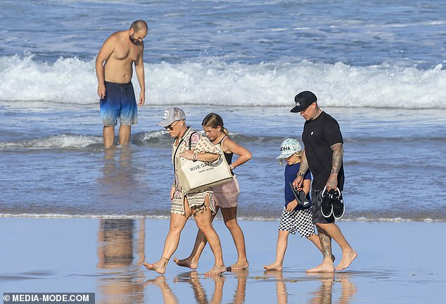 Семья из четырех человек решила осмотреть достопримечательности, прогуливаясь по пляжу.