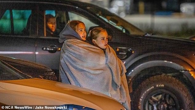 Пара решительных свифитов ютятся вместе под одеялом, чтобы пережить 14-градусную погоду в Мельбурне в пятницу, ожидая возможности мельком увидеть Тейлора (на фото)
