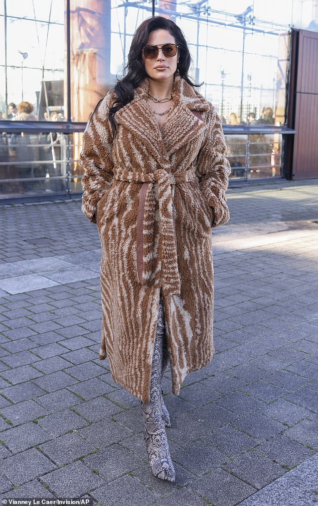 36-летняя модель Эшли Грэм также стильно появилась на мероприятии в уютном бежевом пальто и длинных ботинках из змеиной кожи.