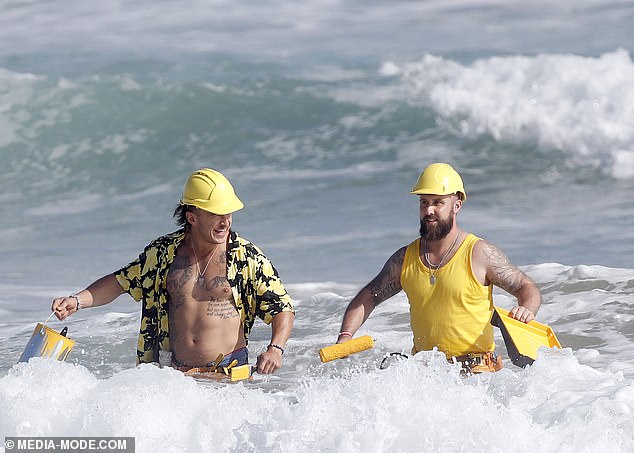Желтая команда, состоящая из двух крепких мужчин в возрасте около 20 лет, продемонстрировала свою силу, уверенно пробираясь по воде, неся банки с краской и валики.
