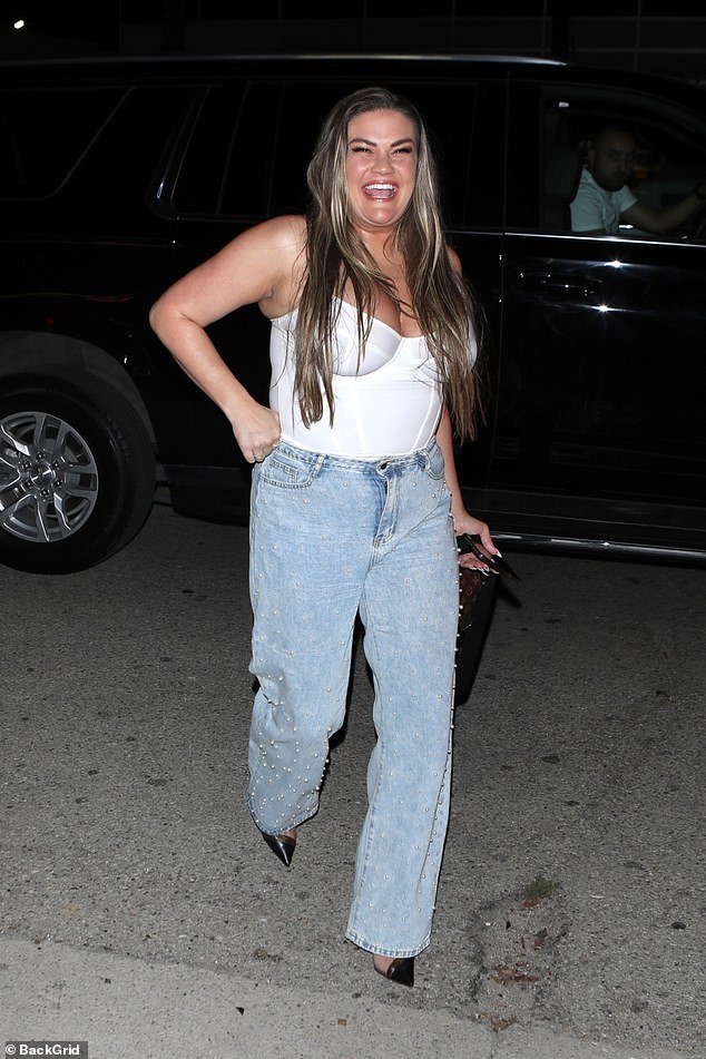 На мероприятии 35-летняя звезда реалити-шоу надела белое боди с глубоким вырезом и светлые синие джинсы, украшенные мелким белым жемчугом.