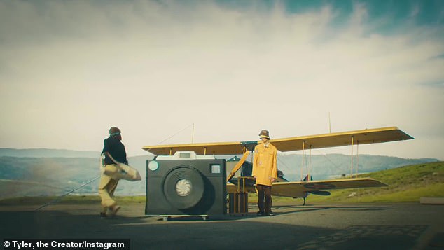 Закулисный фильм завершился тем, что Тайлер вытащил свою огромную камеру на ветреную площадку с желтым самолетом на заднем плане.