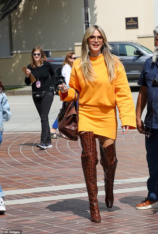 Ее предыдущий наряд состоял из мешковатого оранжевого топа с длинными рукавами в сочетании с приталенной мини-юбкой того же цвета.