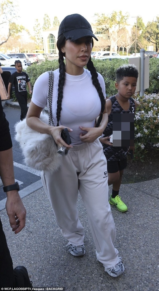 На плече модница носила пушистую белую сумочку Balenciaga с серебристыми ремешками-цепочками.