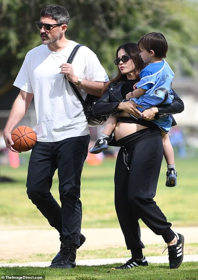 Беременная Дженна Деван, 43 года, демонстрирует свою растущую шишку в укороченном топе и удобных спортивных штанах во время семейной прогулки в Лос-Анджелесе… готовясь к рождению третьего ребенка