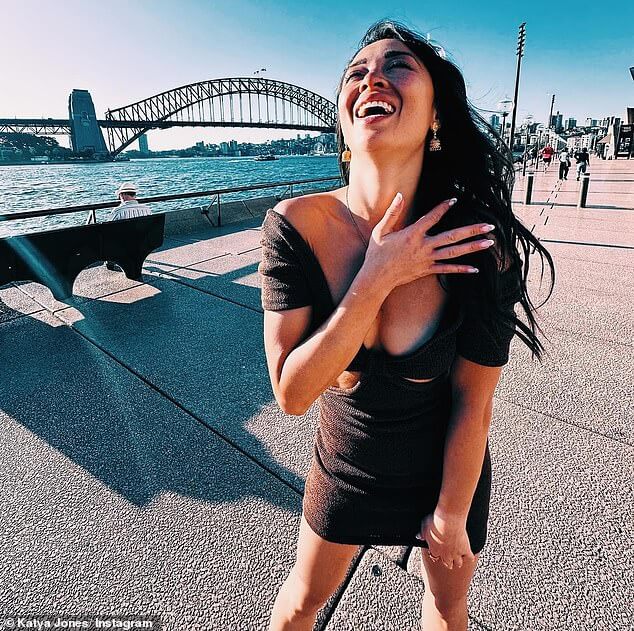 Катя Джонс демонстрирует пышную грудь в маленьком черном мини-платье с вырезом, позируя для забавных снимков в Австралии.