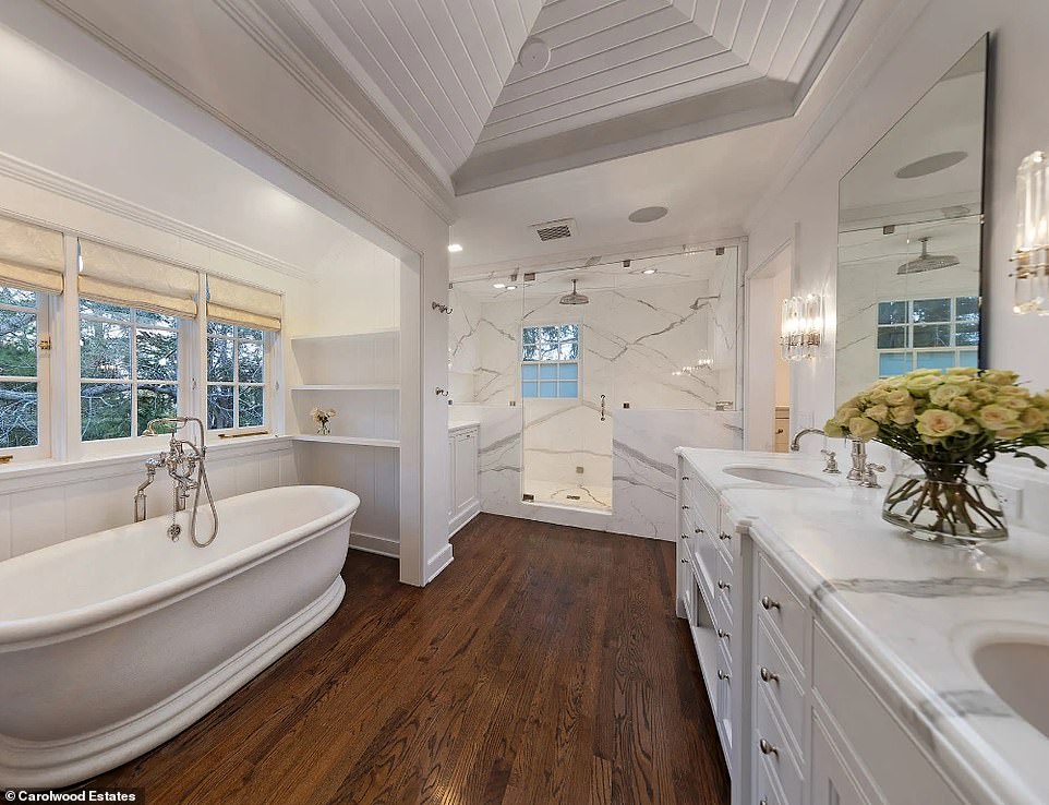 Главной достопримечательностью этой красиво оформленной ванной комнаты с деревянным полом является ванна в фермерском стиле.