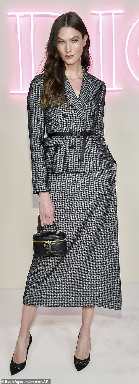 31-летняя модель Карли Клосс демонстрирует модную фигуру в костюме с юбкой в ​​ломаную клетку.