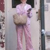 27-летняя Мэйси Уильямс затянулась сигаретой, надев шикарный розовый наряд в Нью-Йорке в четверг, включая полосатые пижамные штаны и тапочки без спинки.