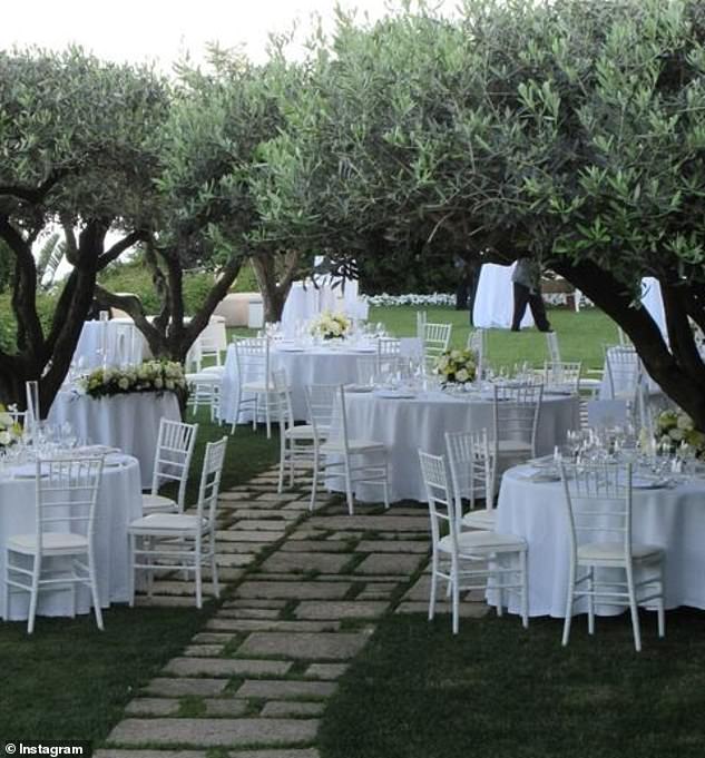 Ужин проходил в уединенном саду с видом на побережье, столы были украшены белыми скатертями и цветами.