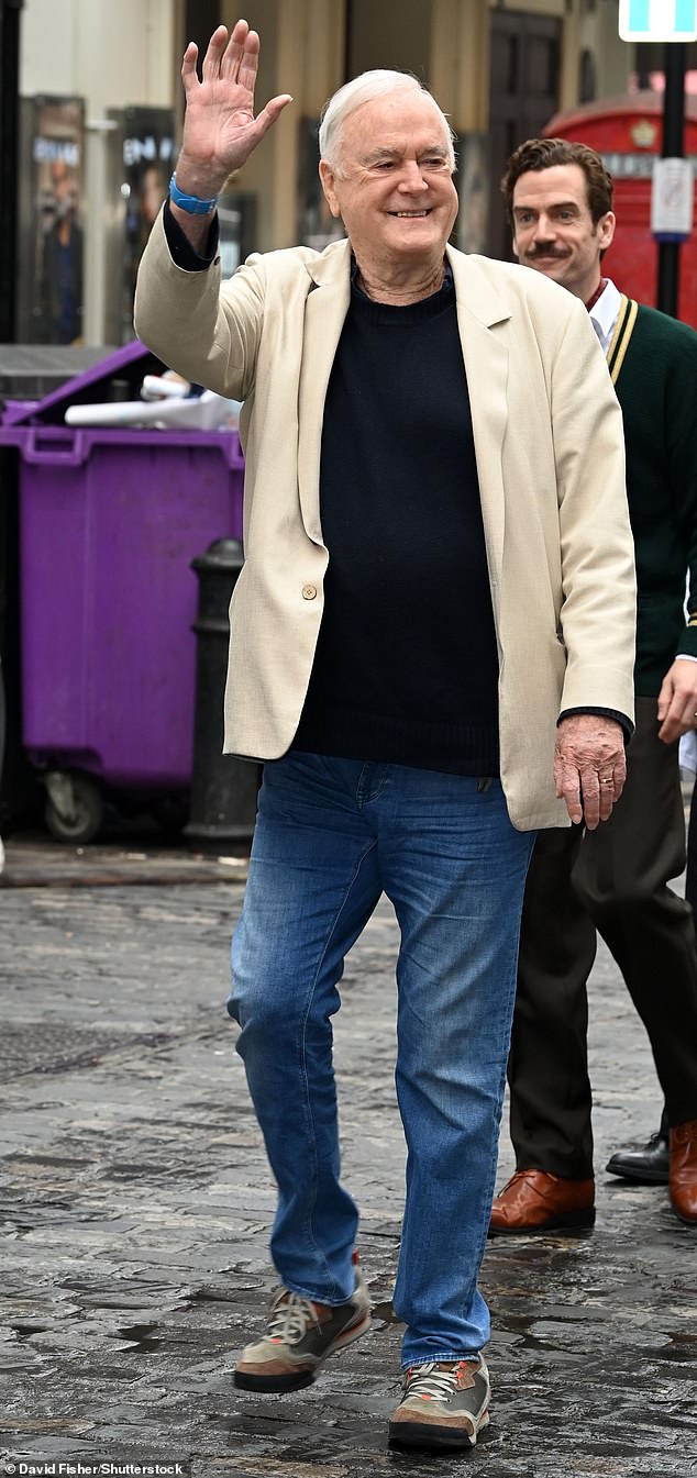 Актер улыбался, когда прибыл на пик шоу в Вест-Энде, одетый в синие джинсы, темно-коричневые и серые кроссовки, простую черную футболку и светло-бежевую куртку.