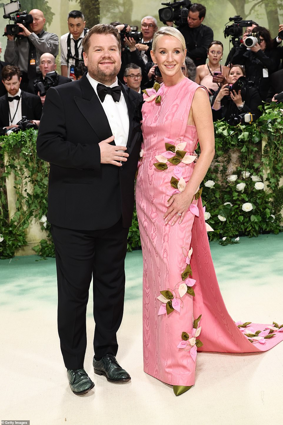 Джеймс Корден выглядел щеголевато в классическом черном смокинге, позируя рядом со своей женой Джулией Кэри, которая сияла в розовом платье без рукавов с цветочным декором.