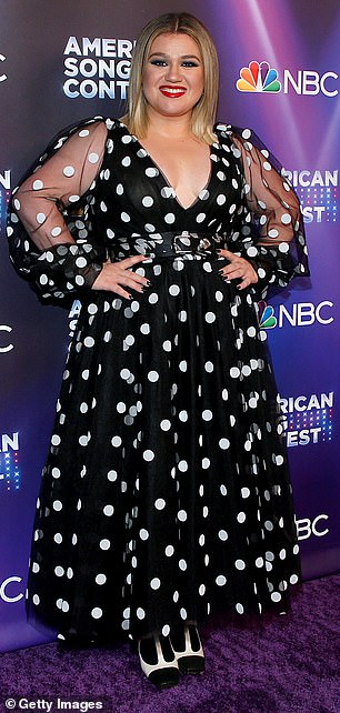 Ветеран American Idol казалась невероятно стройной в платье с белой верхней частью и черной нижней частью на своем ток-шоу.  Виден в марте 2022 г.