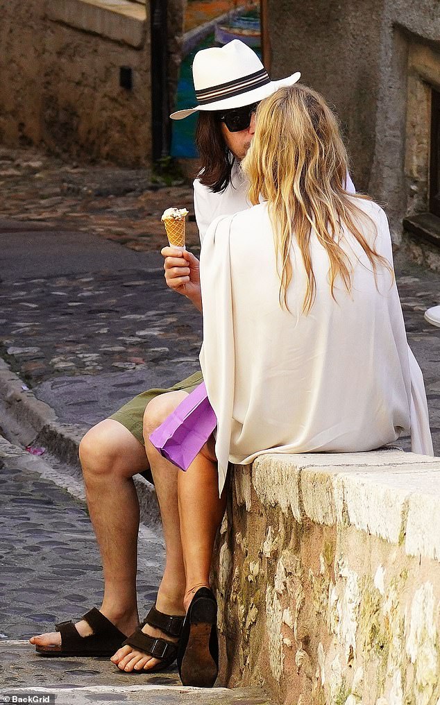 Они сидели на стене и болтали, пока ели мороженое.