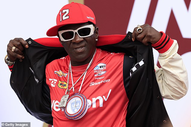 Рэпер Flavor Flav также был сфотографирован до того, как сильный дождь задержал старт гонки.