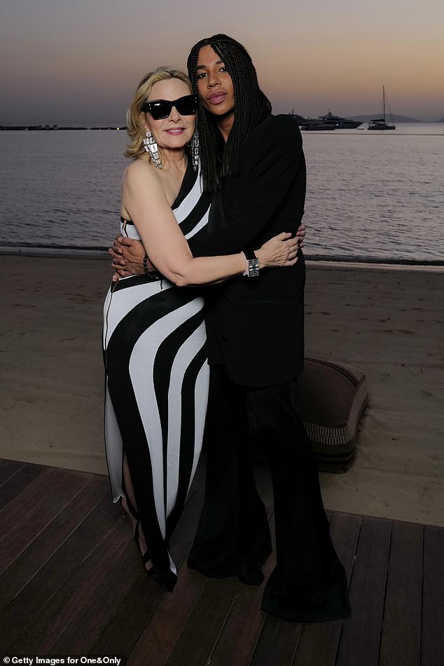 Гламурную звезду также запечатлели обнимающей известного французского дизайнера Оливье Рустена, когда пара позировала на фоне потрясающего заката.