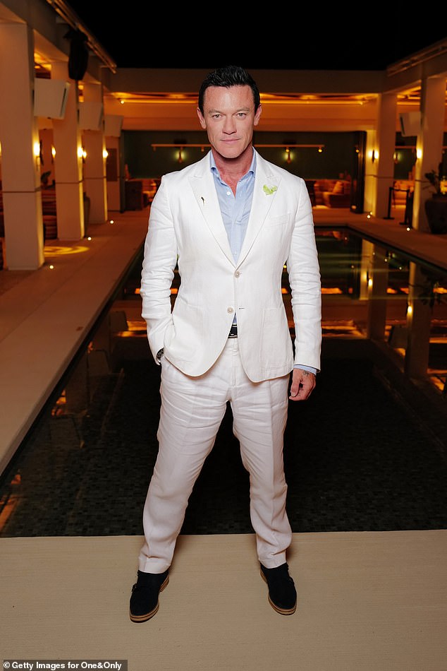 Голливудская звезда Люк Эванс демонстрирует учтивую фигуру в белом костюме и нежно-голубой рубашке.