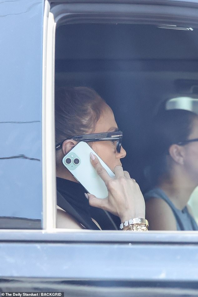 Певица и актриса завязала свои каштановые локоны сзади и надела очки в черной оправе, когда ее сфотографировали разговаривающей по телефону, сидя на пассажирском сиденье.