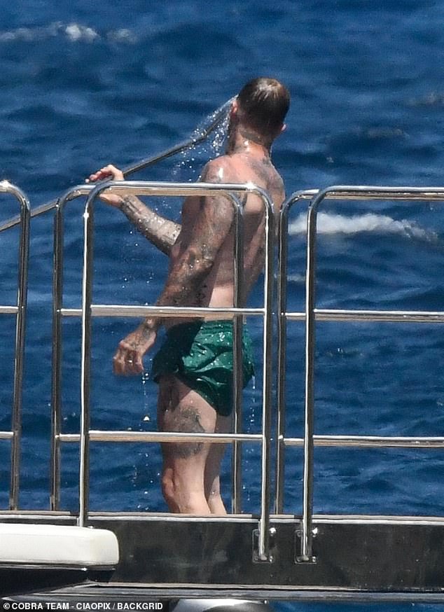 Дэвид охладился от жары на Сардинии, приняв душ на палубе, прежде чем присоединиться к жене