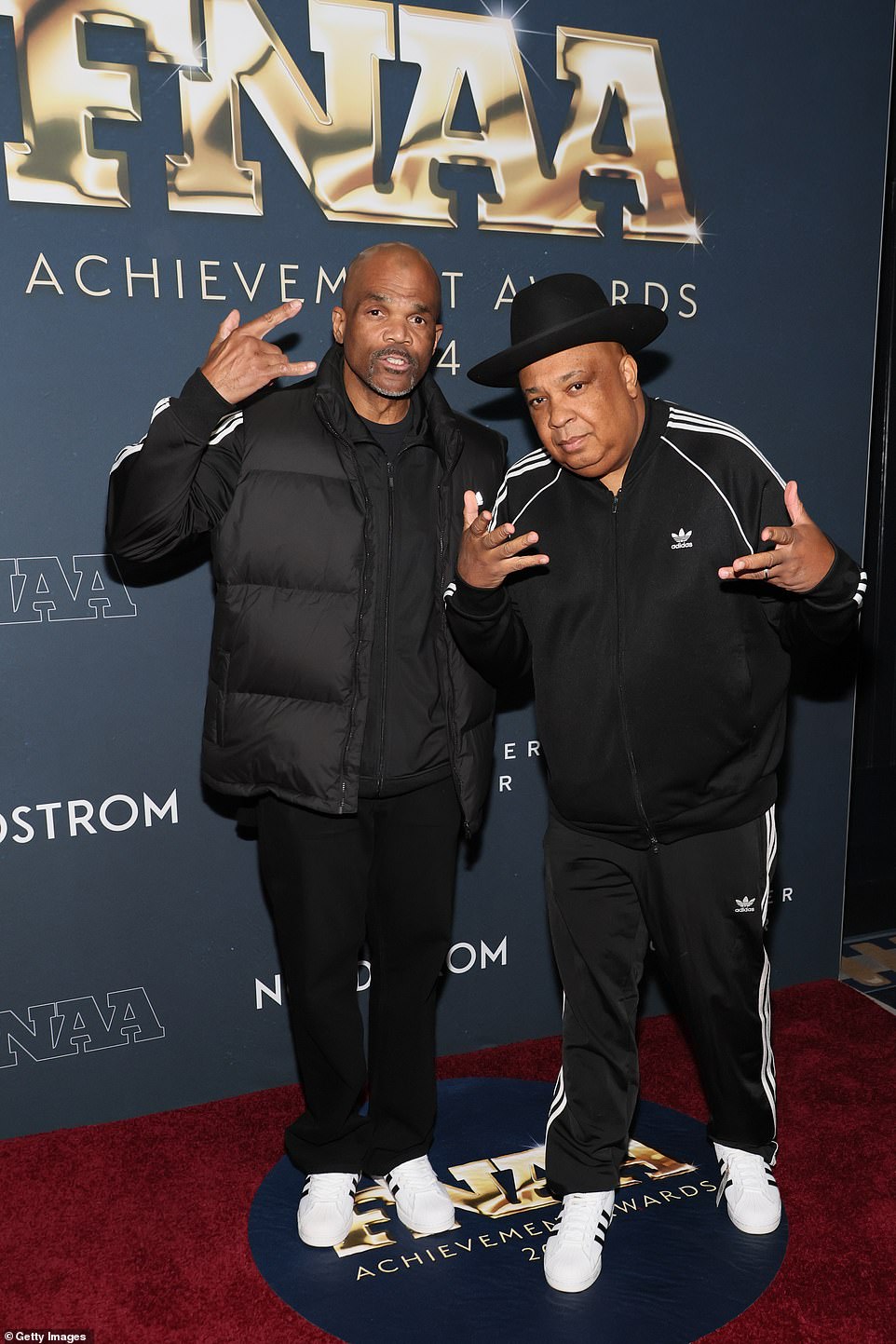 Дэррил МакДэниелс из Run-DMC и Джозеф 'Преподобный. Run' Simmons с гордостью надел кроссовки Adidas и спортивную одежду на церемонию в Нью-Йорке.