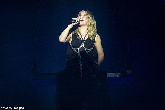 Для макияжа суперзвезда выбрала смелую палитру с ярко-оранжевыми тенями для век и розовым блеском для губ.